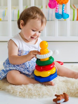 baby-girl-playing-with-educational-toy-nursery-1.jpg